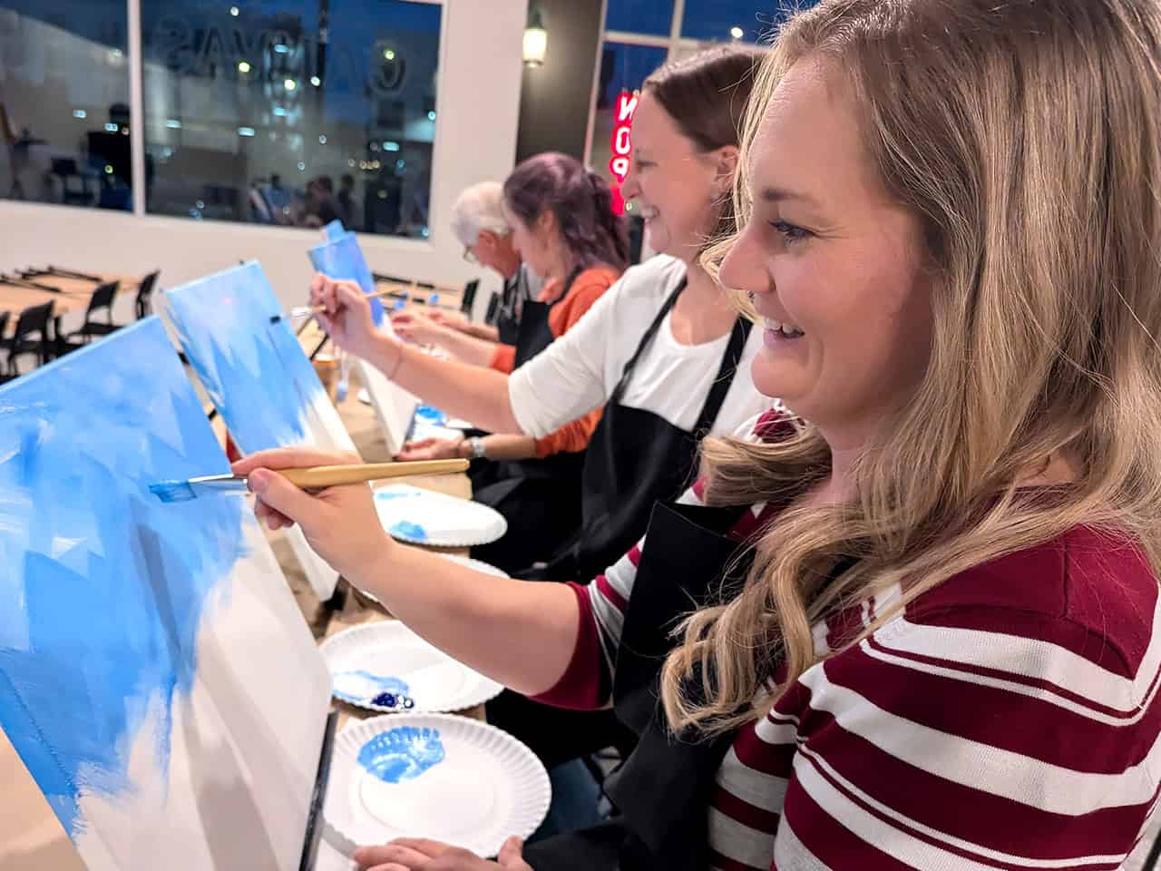 Women having fun painting an outdoor scene